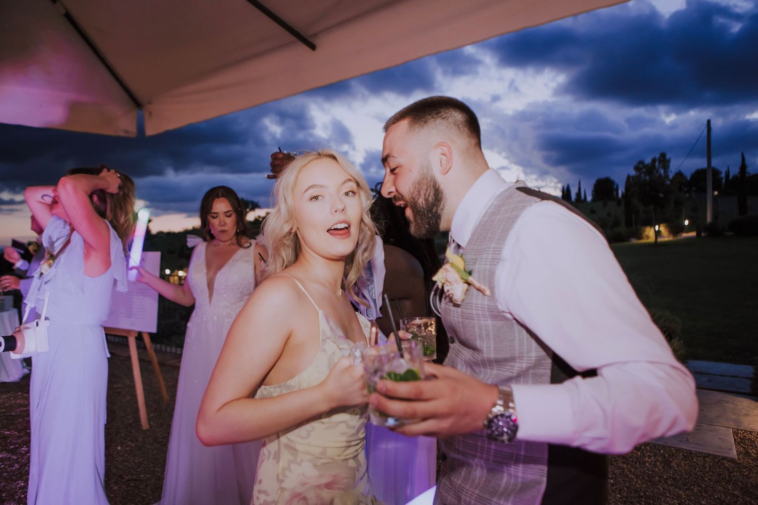 Joyful celebration moments captured during an outdoor evening wedding reception.