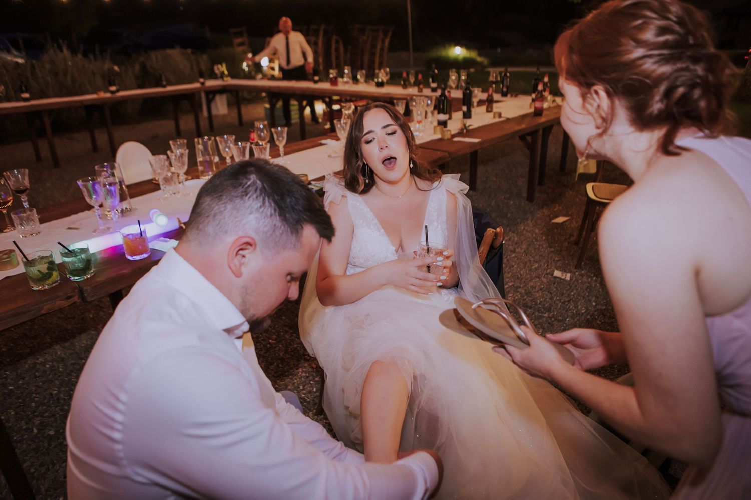 Fun moment captured during wedding reception as guests celebrate outdoors at dusk.