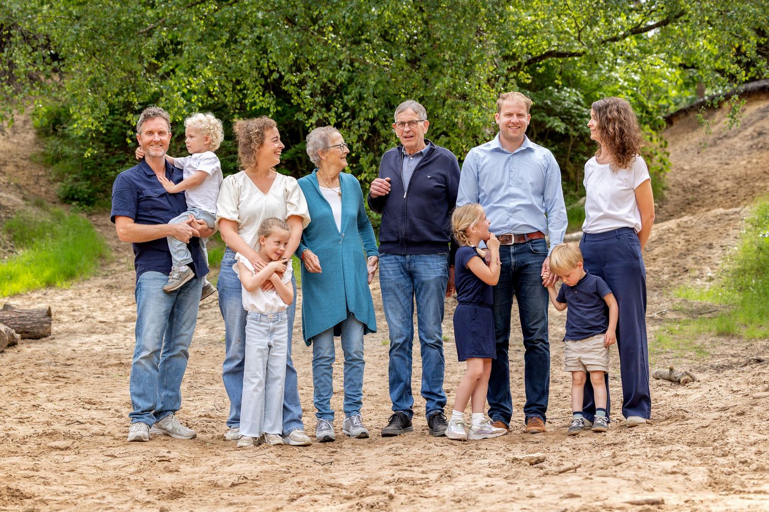 vrolijke gezinsfoto voor tarweveld in haarle. In witte en beige kleding. gestylde fotoshoot
