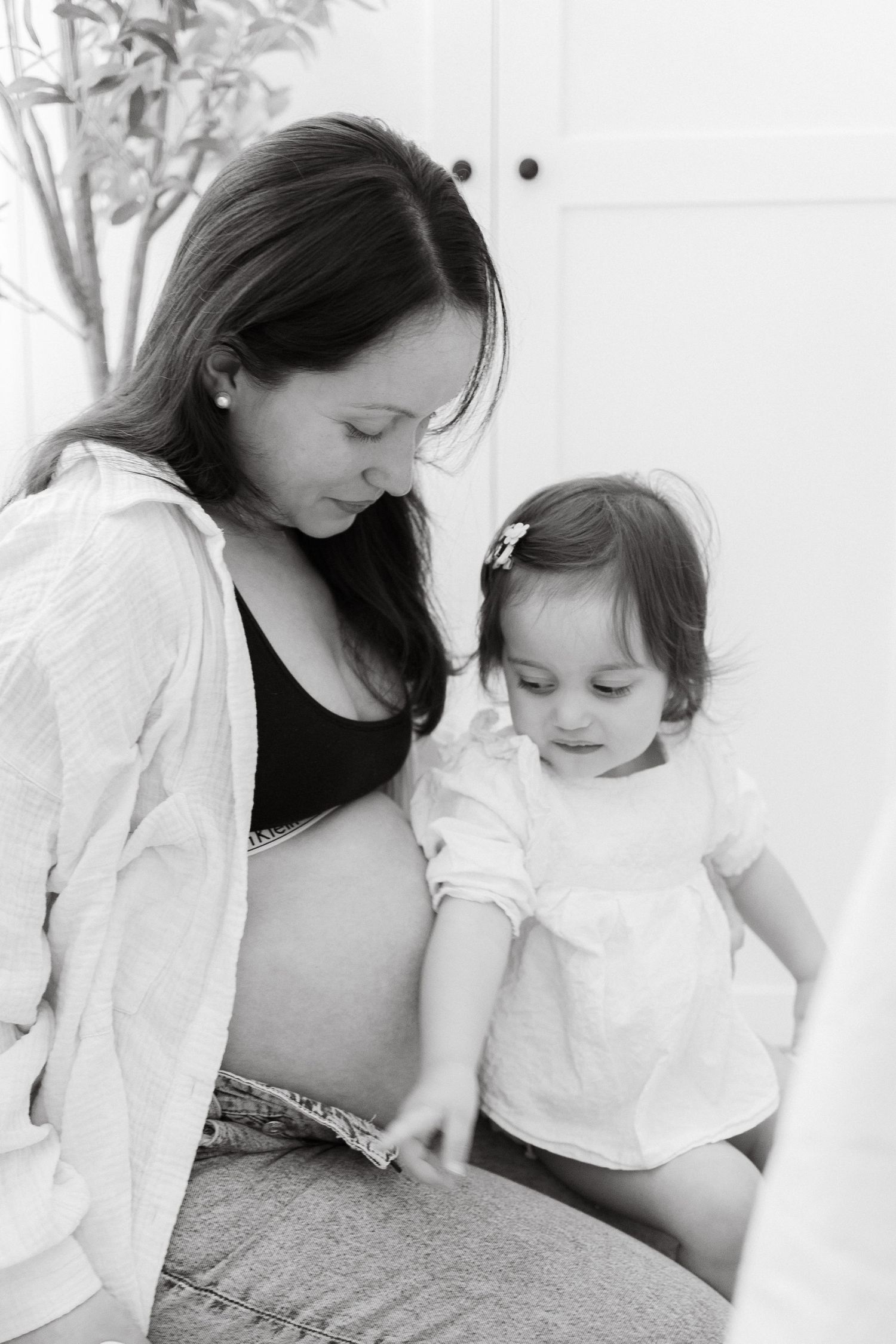 Tender black and white maternity moment shared between parent and child.
