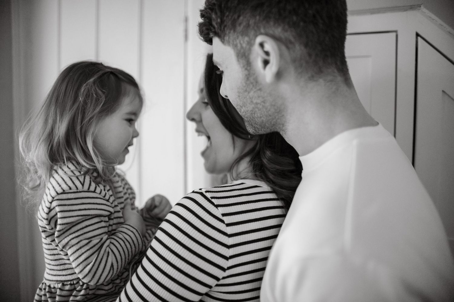 Black and white portrait of family sharing intimate moment.