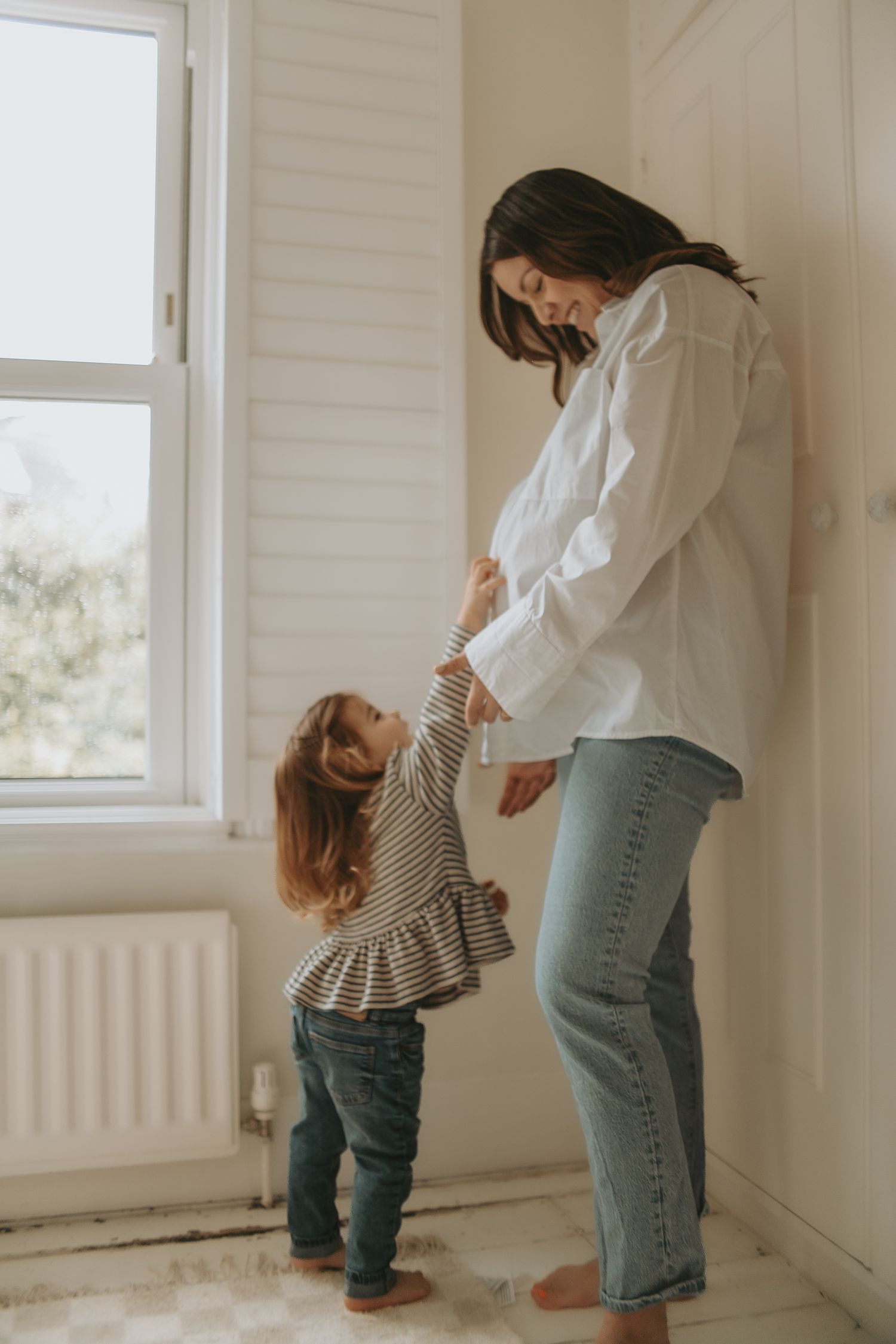 Parent and child sharing sweet moment by bright window.
