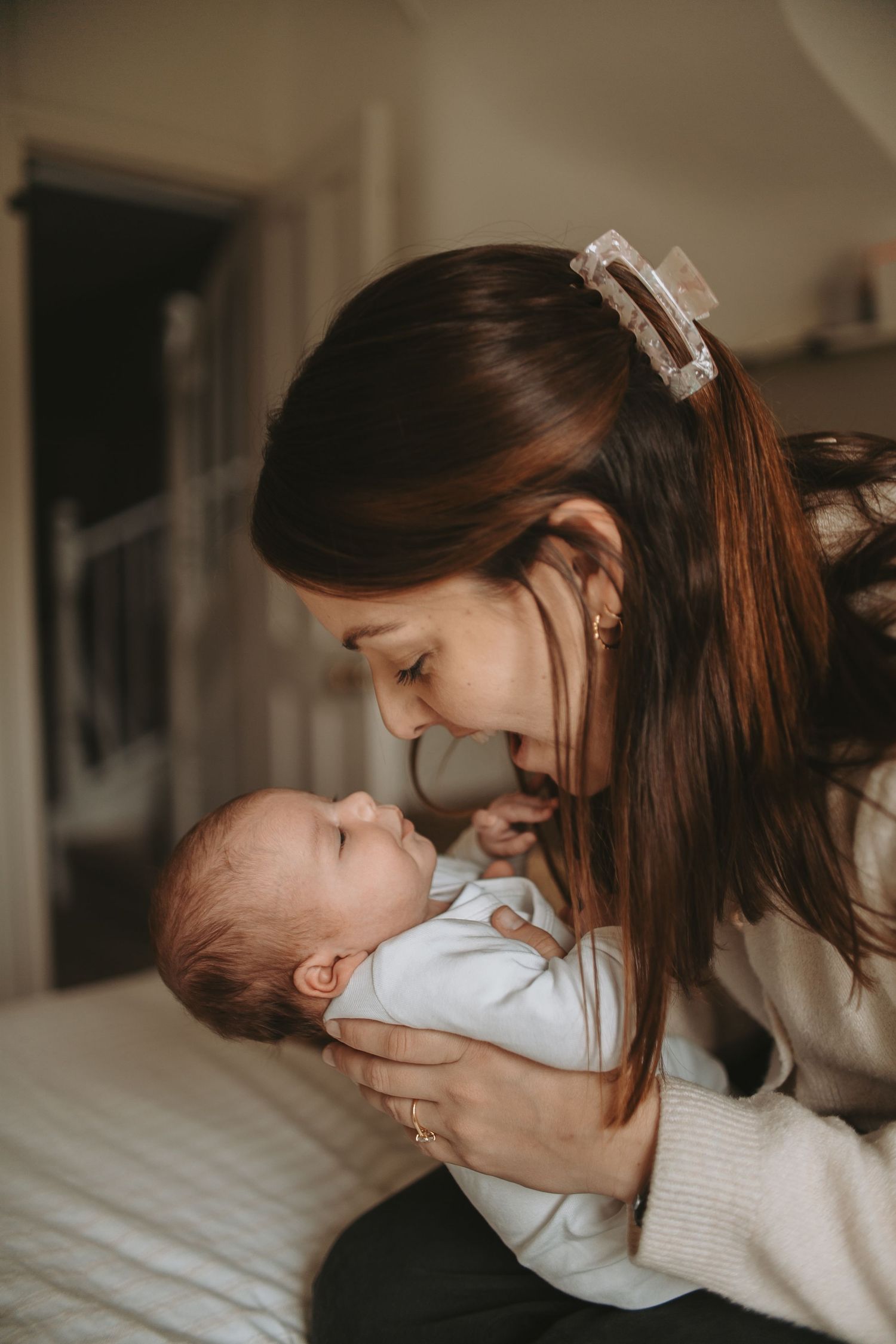 An intimate moment between parent and baby in warm lighting.