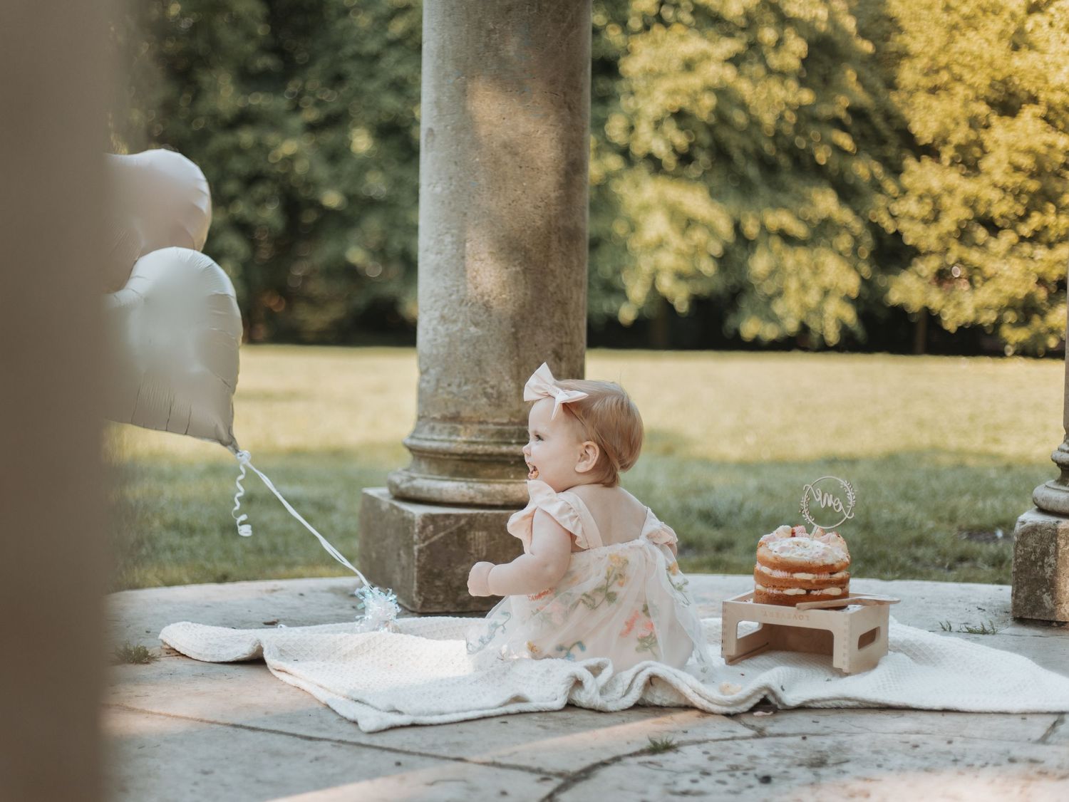 Professional photo setup outdoors with stone columns and cake smash props.