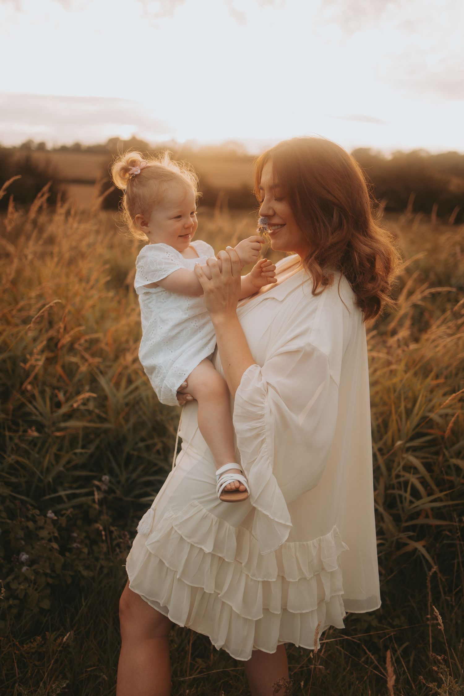 A heartwarming interaction captured in warm sunset light amidst tall grass.
