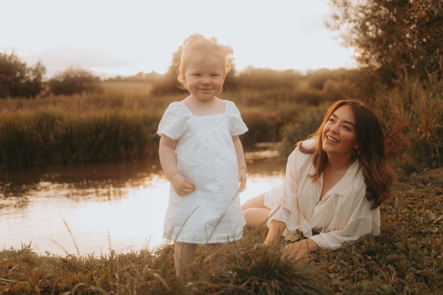 Joyful outdoor photography session during golden hour by a serene lake.