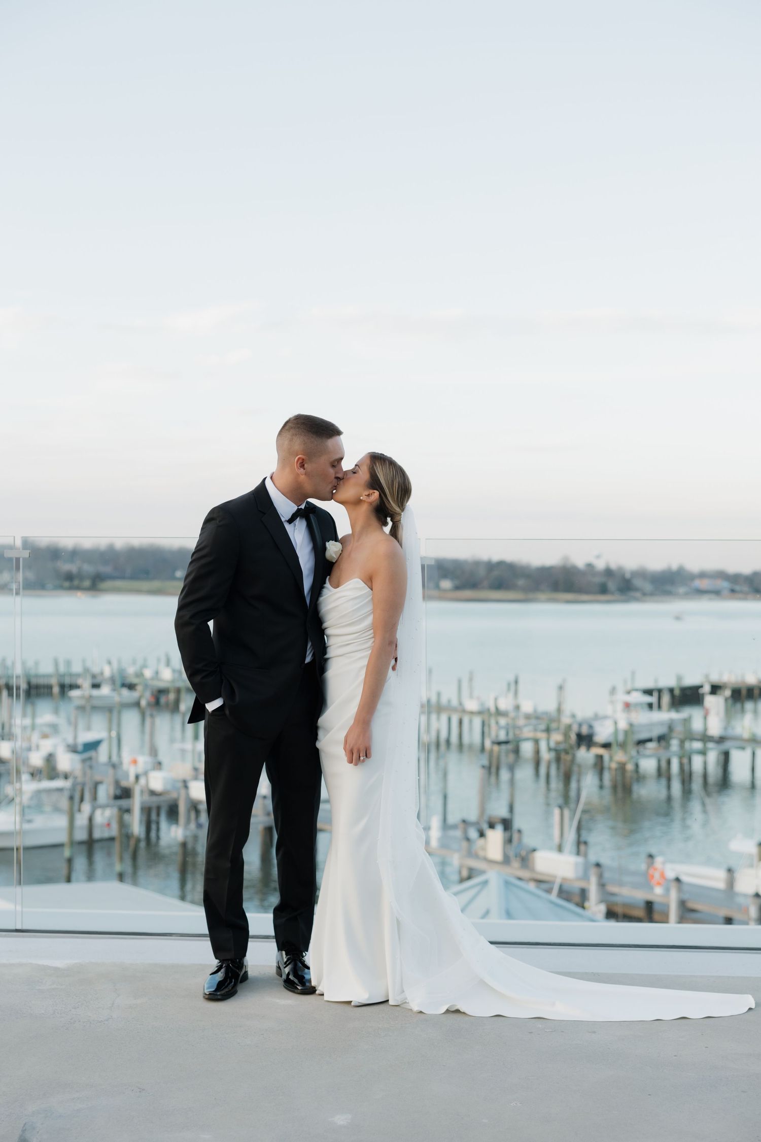 Joyful candid moment of a couple walking on the beach after their wedding ceremony with guests in floral dresses.