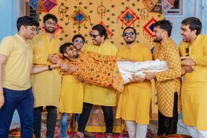 Joyful group wearing matching yellow outfits celebrate with confetti and streamers at an indoor event.