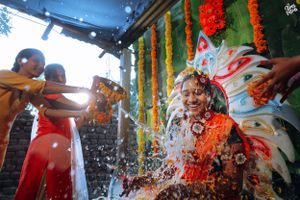 Festive Indian celebration with water splashing and marigold decorations.