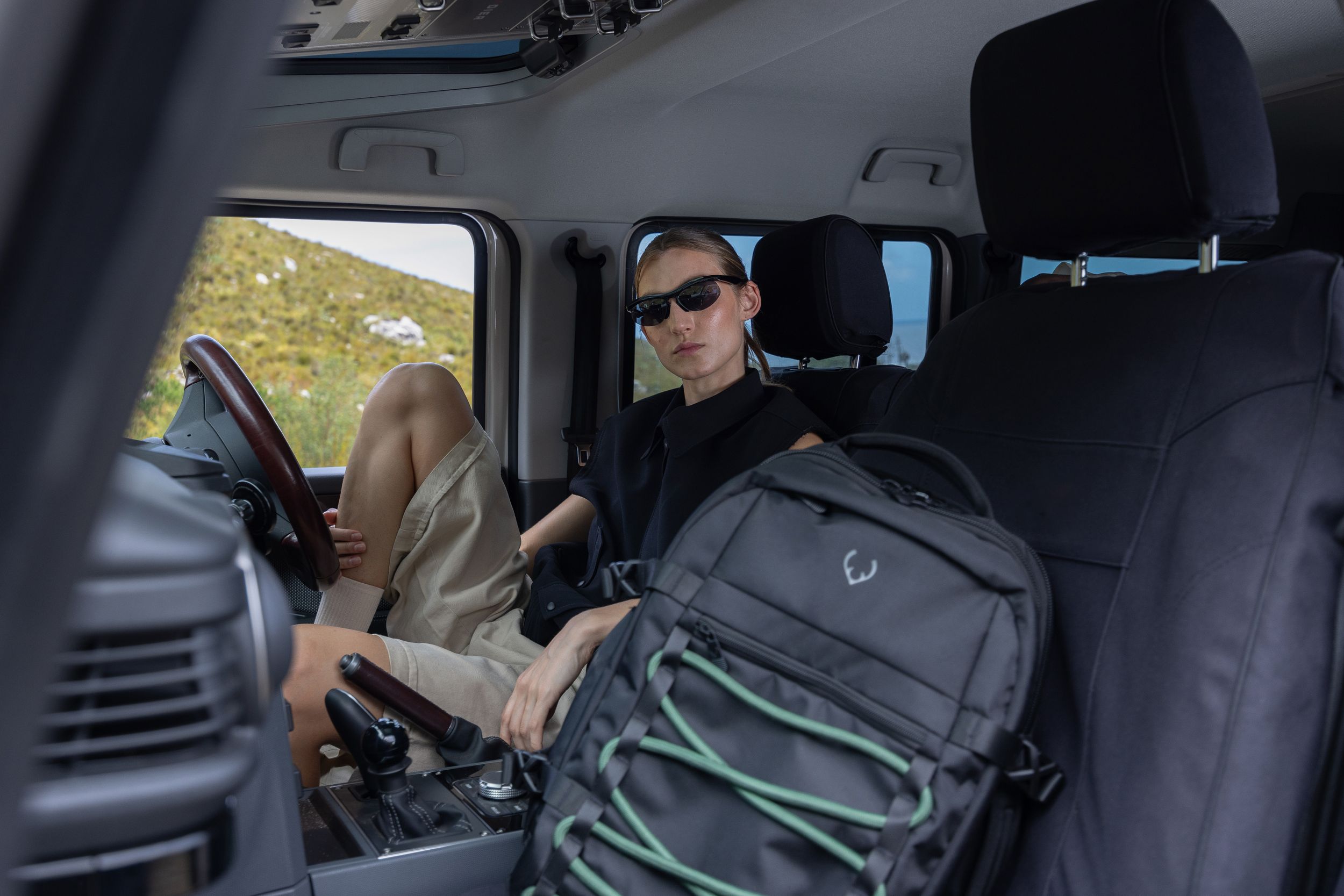 Interior car shot showing Antler backpack on passenger seat.