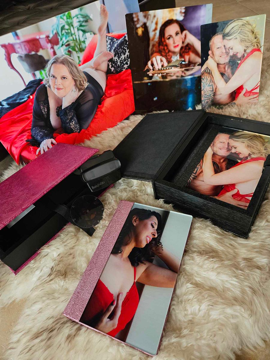 Collection of professional photography prints featuring artistic boudoir portraits displayed on textured surfaces.
