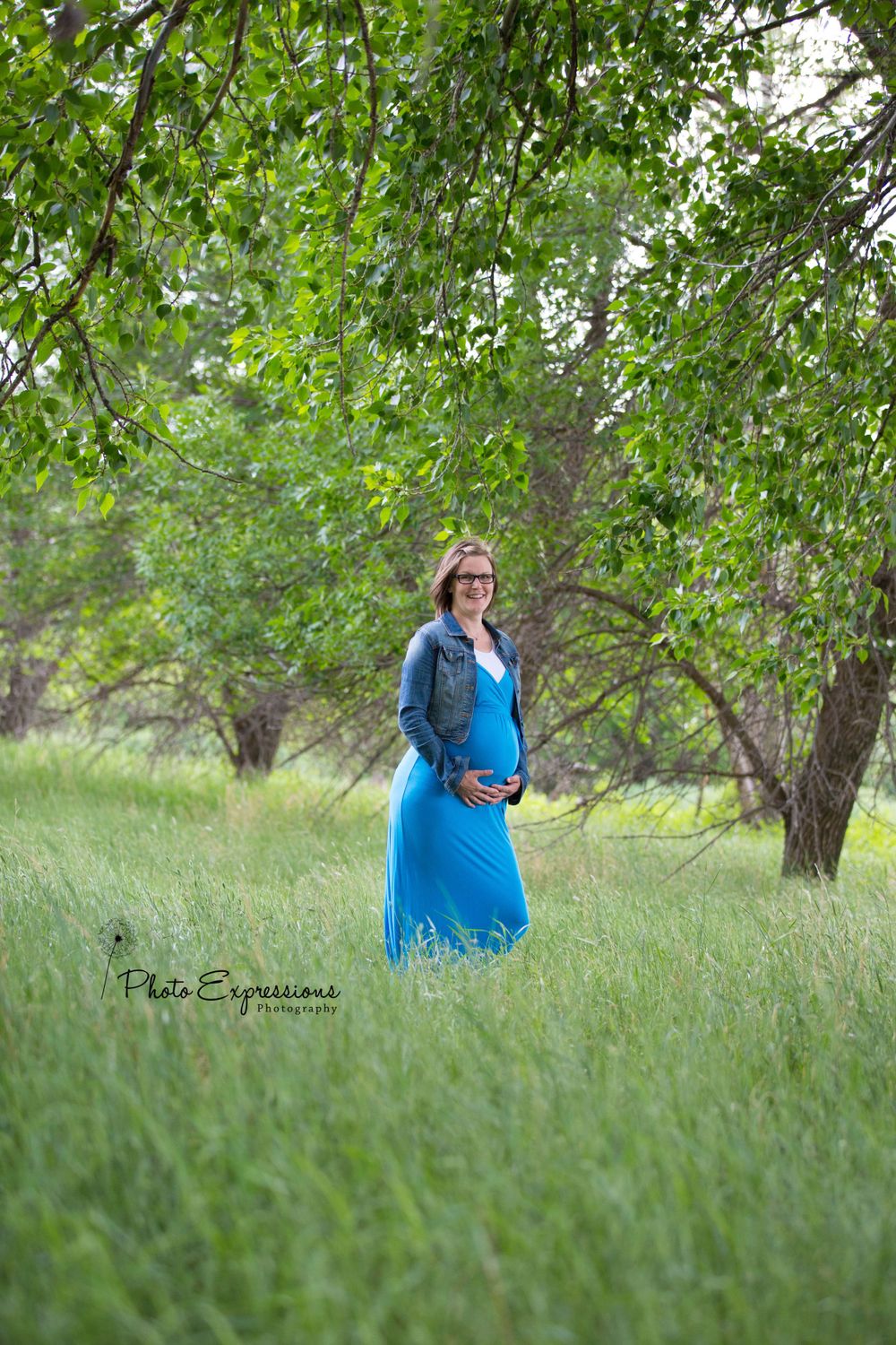 Person in blue dress walking through lush green garden setting.