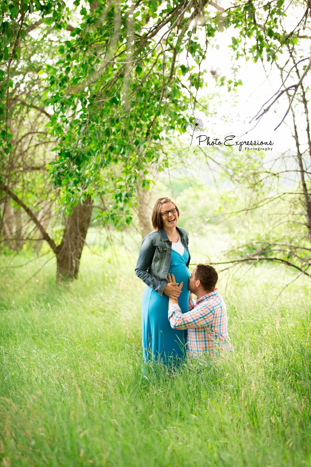 Outdoor photo session in grassy field under blooming trees.