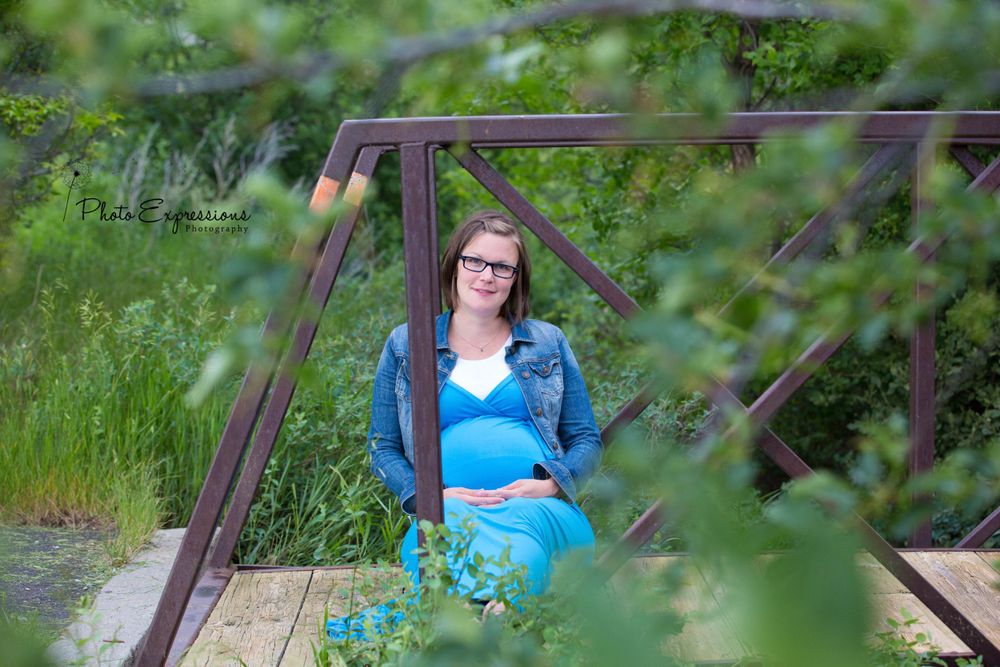 Portrait session on rustic wooden bridge with natural foliage.