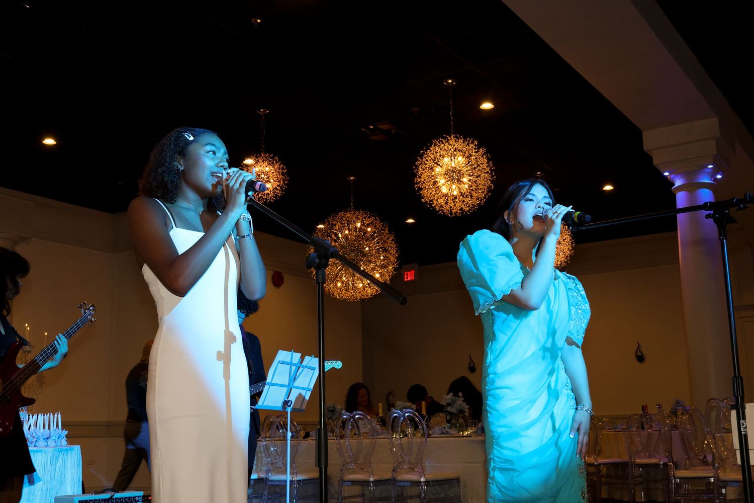 Two girls singing in blue light