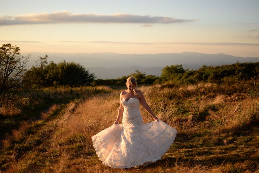 Dramatic landscape photography session at golden hour with flowing fabric movement.