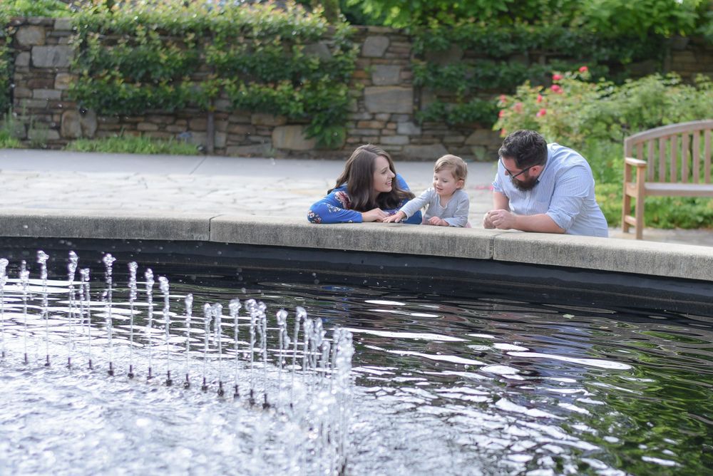 Water fountain creates peaceful ambiance in garden setting with people relaxing nearby.