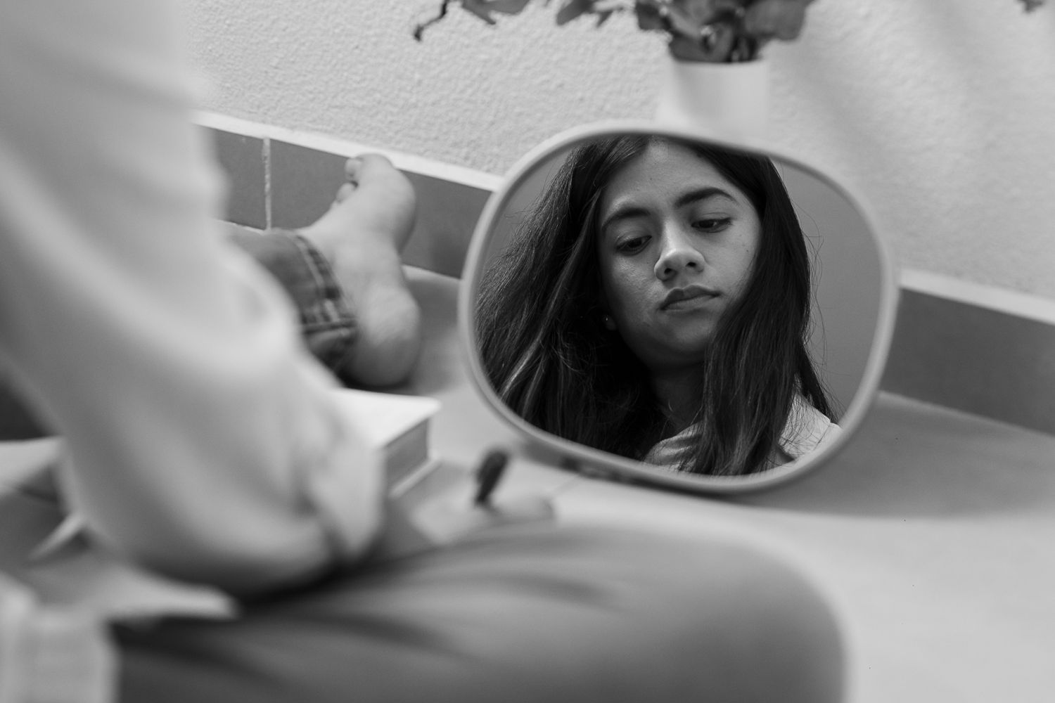A circular mirror reflection shows a black and white composition with artistic framing.