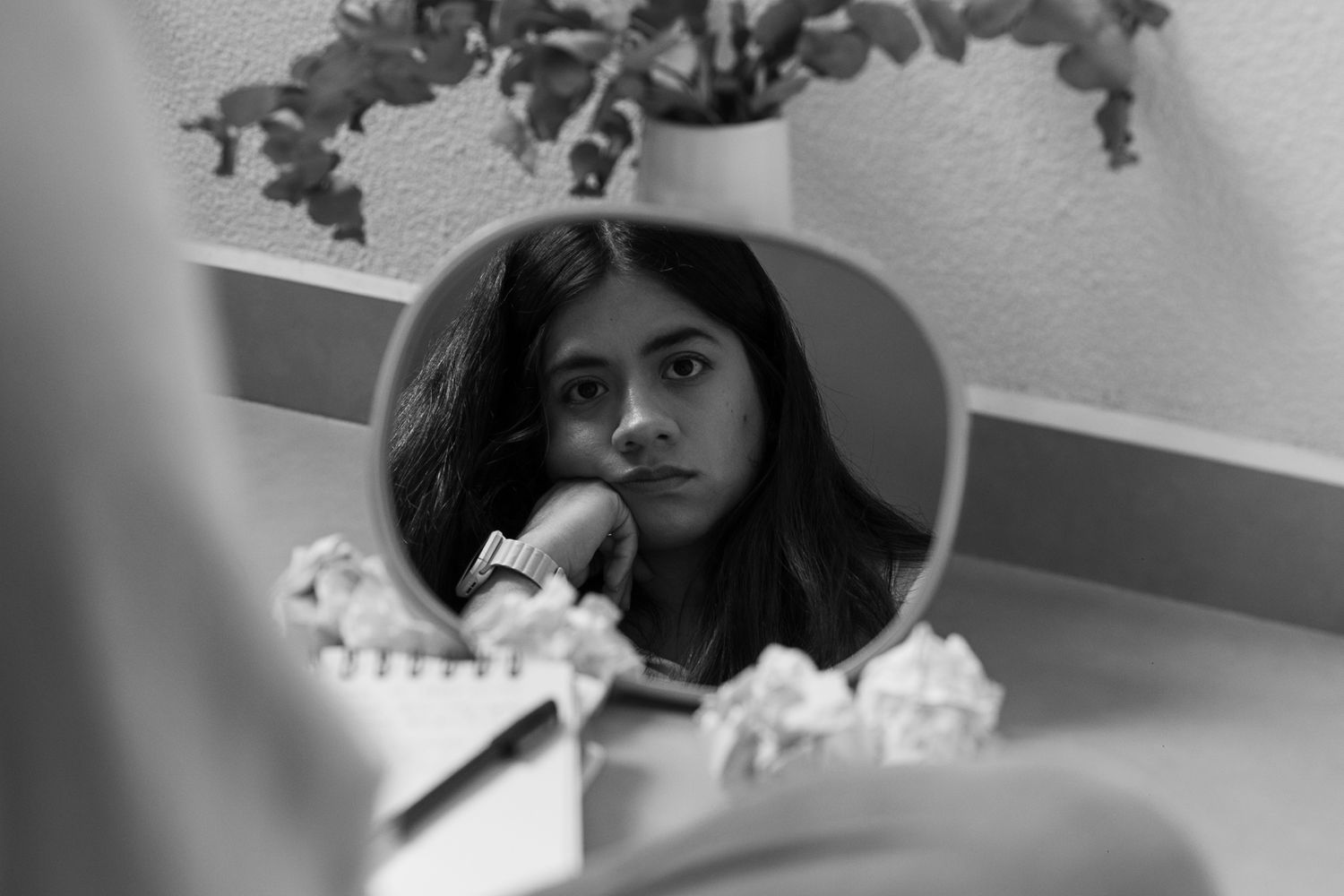 A moody black and white composition showing a reflection in a circular mirror.