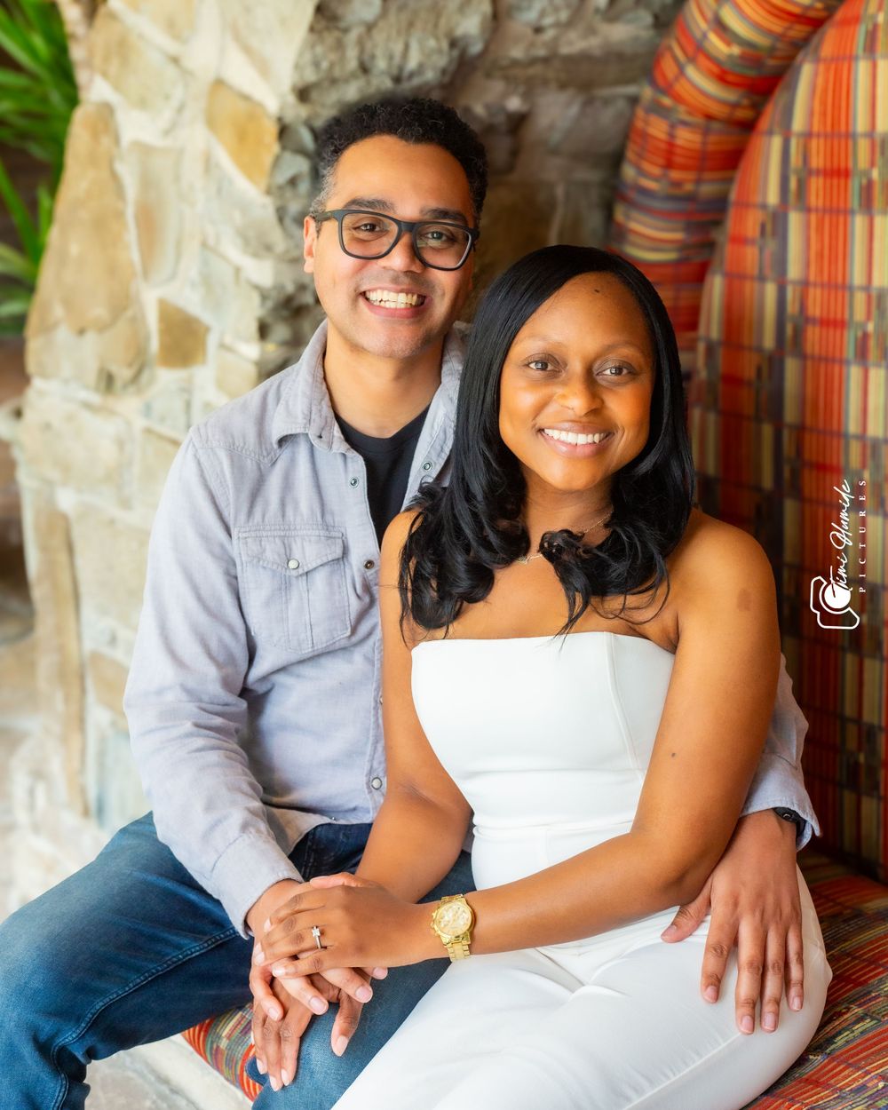 A couple poses together on stone steps for an engagement photo.