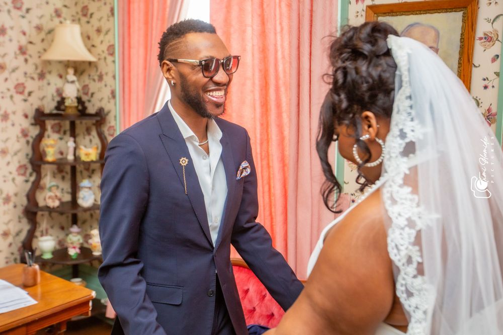 A happy couple shares an intimate moment in a vintage-styled room with floral wallpaper.