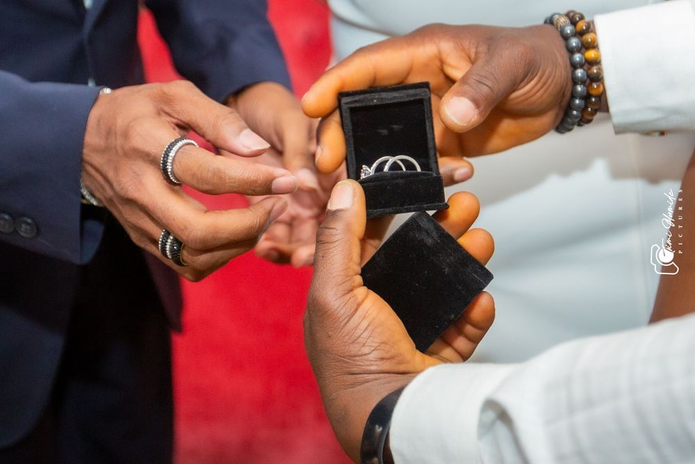 Close-up of hands exchanging wedding rings during a ceremony.