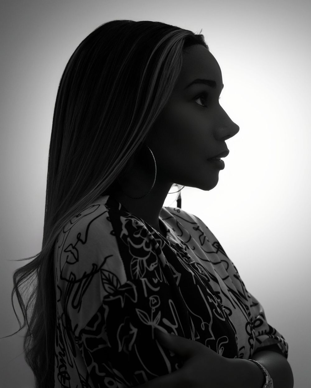 Artistic black and white profile portrait showcasing elegant fashion and lighting.