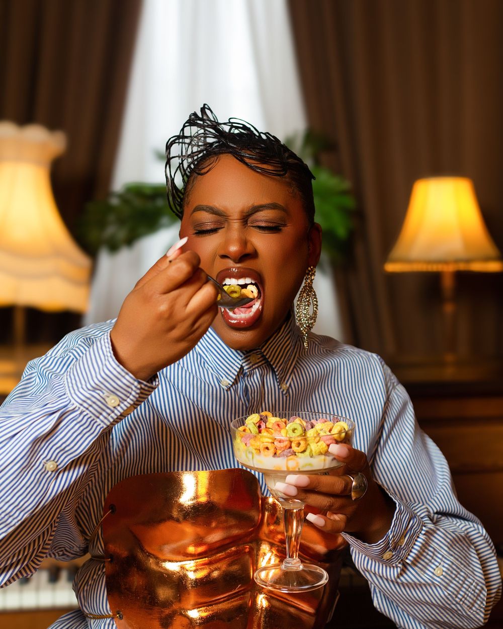 A person enjoys a decadent dessert and beverage in a warmly lit restaurant setting with multiple courses.