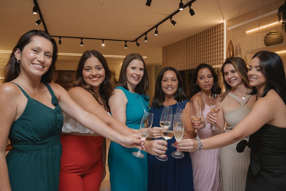 Group of women in formal dresses toasting with champagne glasses at a celebration.