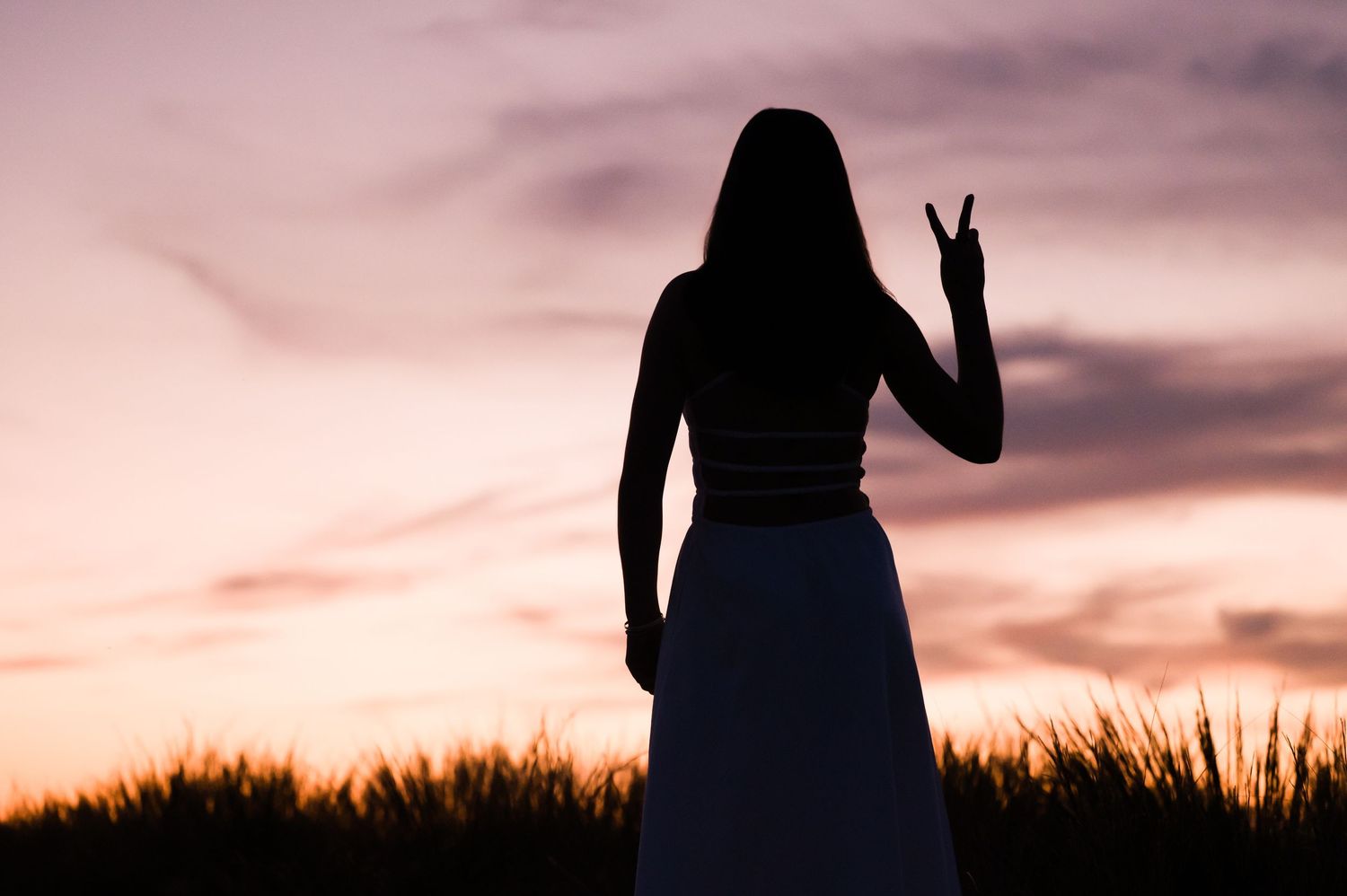 Silhouette of person walking on beach during golden sunset.