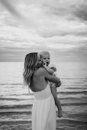 A tender moment captured in black and white on a serene beach.
