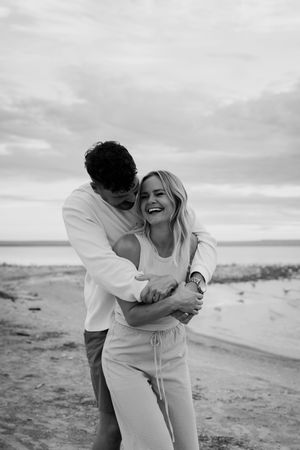 Candid black and white photo of a playful moment on the beach.