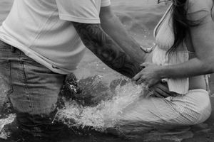 Couple playing in the shallow waves at the beach shore.