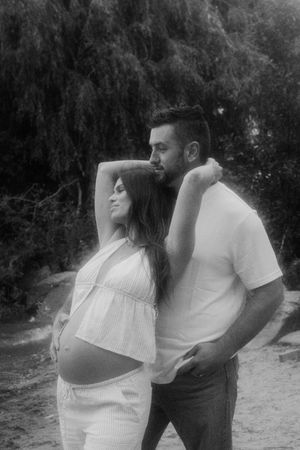Intimate maternity photo session in a wooded beach setting.