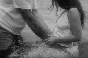 Couple sharing intimate moments together on a beach in black and white.