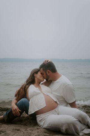 Romantic couple lying on the beach shore in soft lighting.