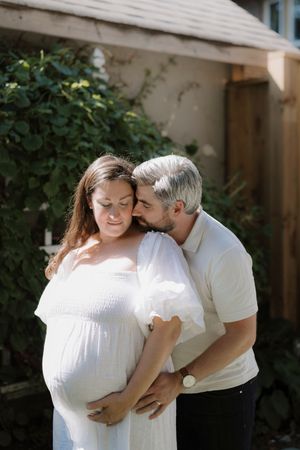 Sun-drenched portraits of couple sharing tender moments in a garden setting.