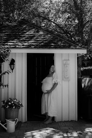 Black and white series showing family interactions near white garden shed.