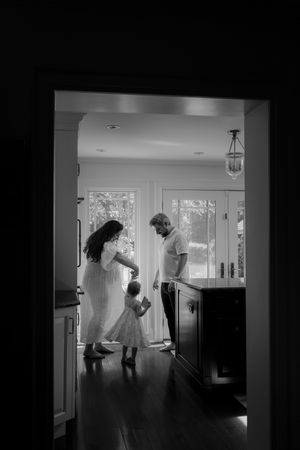 A collection of black and white photos capturing playful moments in a bright hallway.