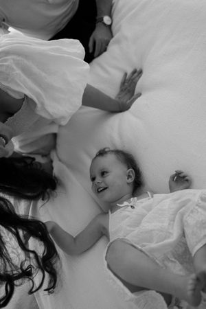 Intimate black and white photos showing gentle interactions on white bedding.