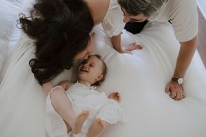 A sequence of candid moments captured in white bedding from above.