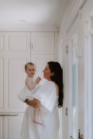 A series of bright, airy photos showing playful interactions in a white hallway.