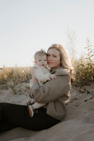 A heartwarming embrace between parent and child on a sandy beach at sunset.