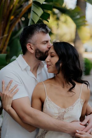 A romantic couple shares intimate moments in a series of tender embraces against a natural outdoor backdrop.