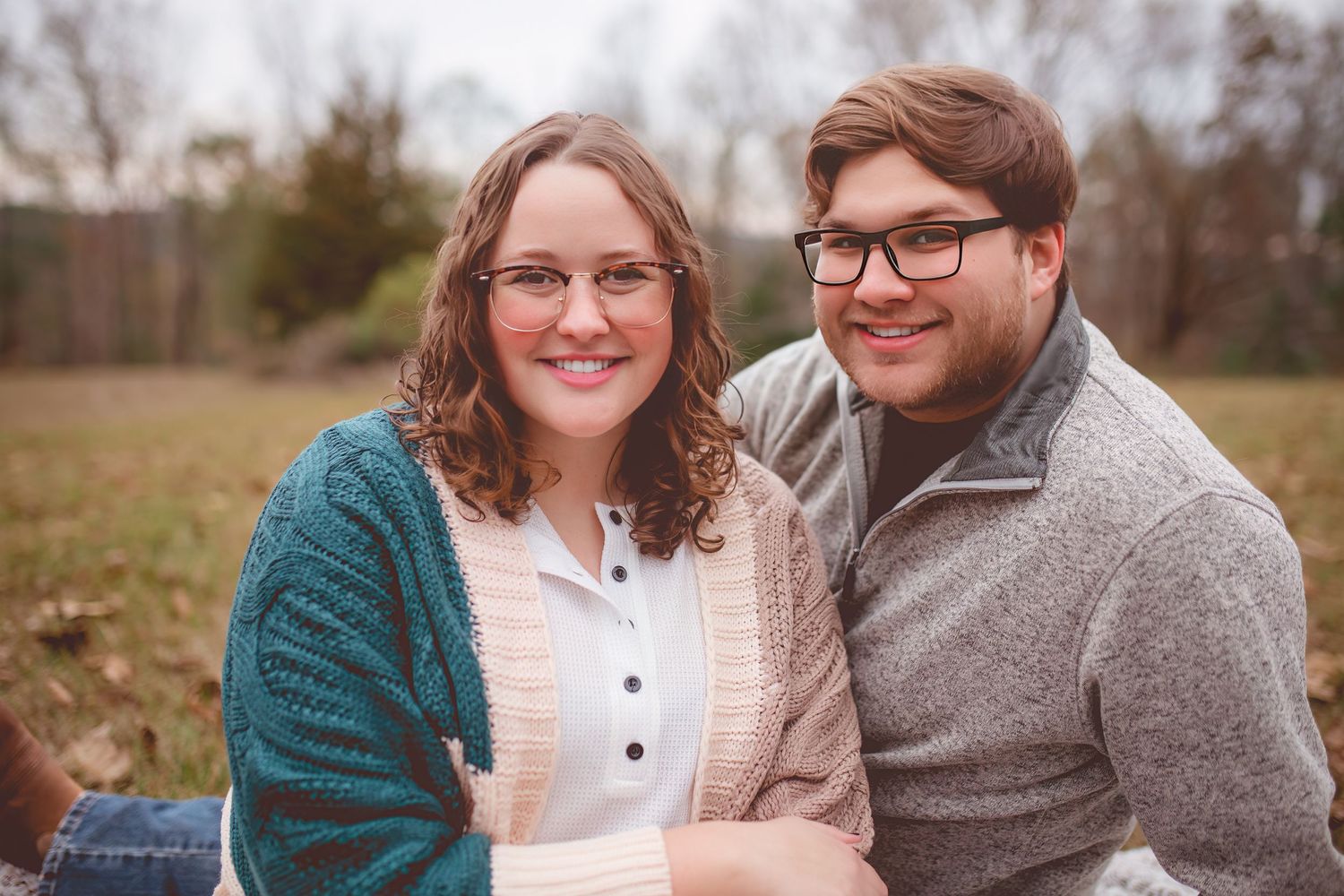 Cozy autumn portrait of couple in sweaters smiling together outdoors.
