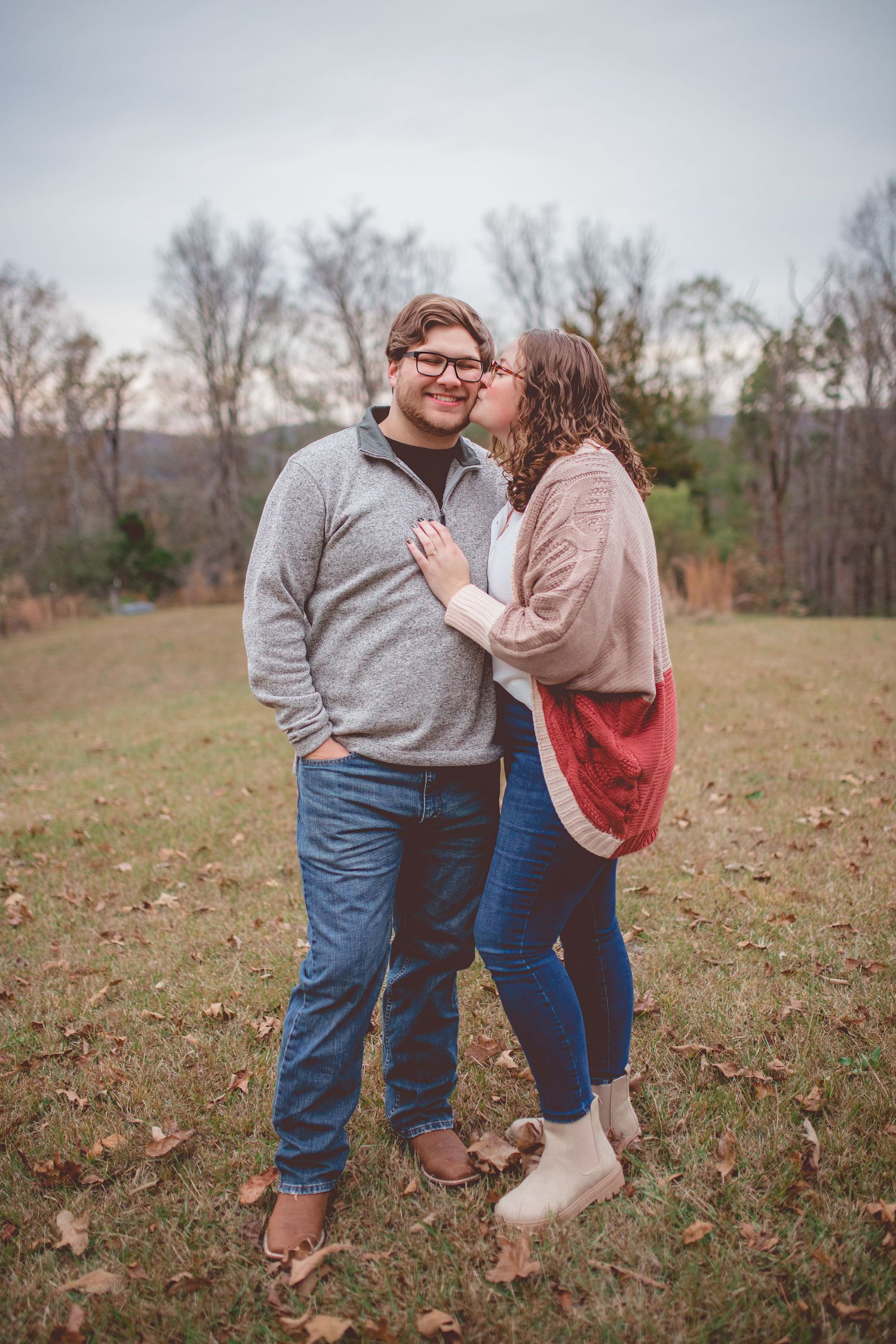 Sweet moment between a couple in casual wear embracing in a fall field.