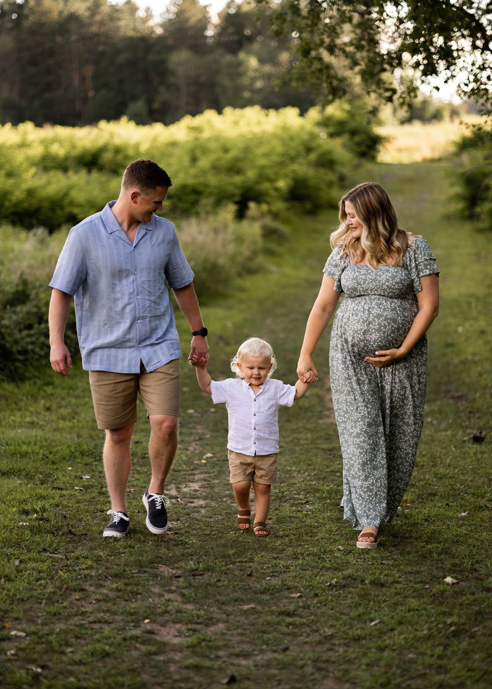 A family walks together on a nature trail during golden hour.