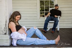 People relaxing casually on a white porch with wooden siding in summertime.
