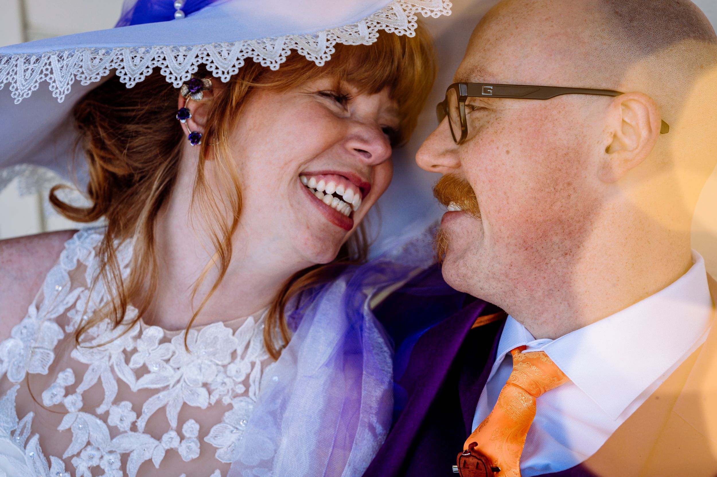 Laughing bride and groom share a joyful moment on their wedding day.