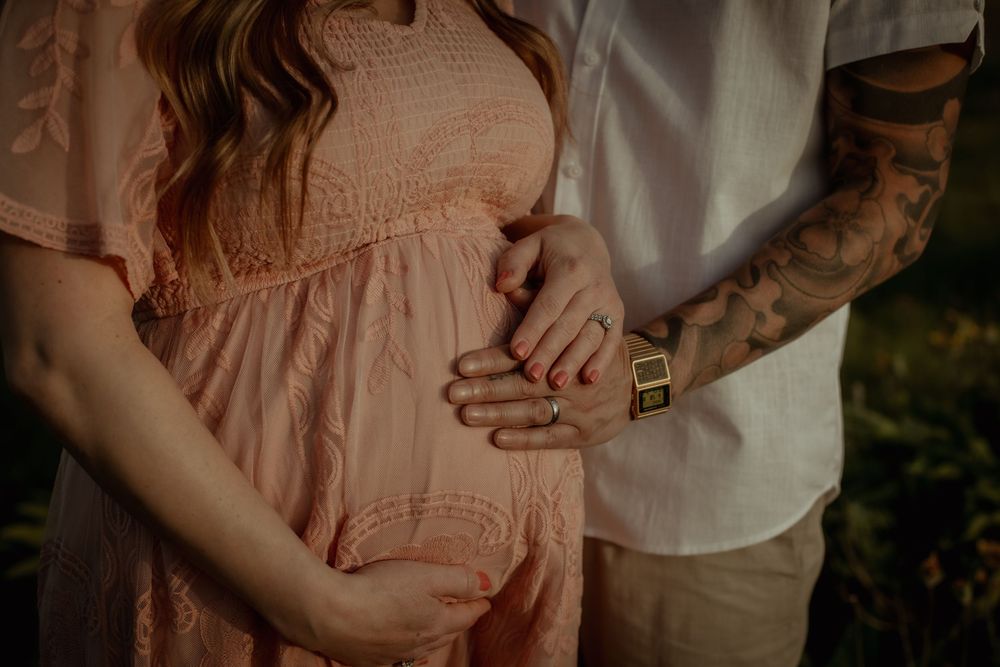 Close-up view of hands holding each other in a tender embrace during an intimate moment.